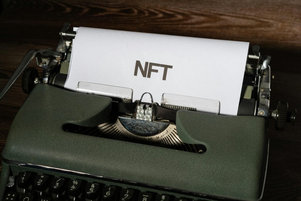 Close-up of a vintage typewriter with a sheet of paper showing the word “NFT” in bold letters.