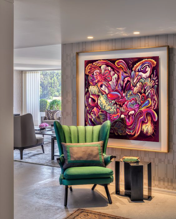Romantic Grotesque painting on canvas in gold frame, abstract surreal artwork with vivid red, purple, and yellow organic forms, blending beauty and distortion, displayed in modern interior.