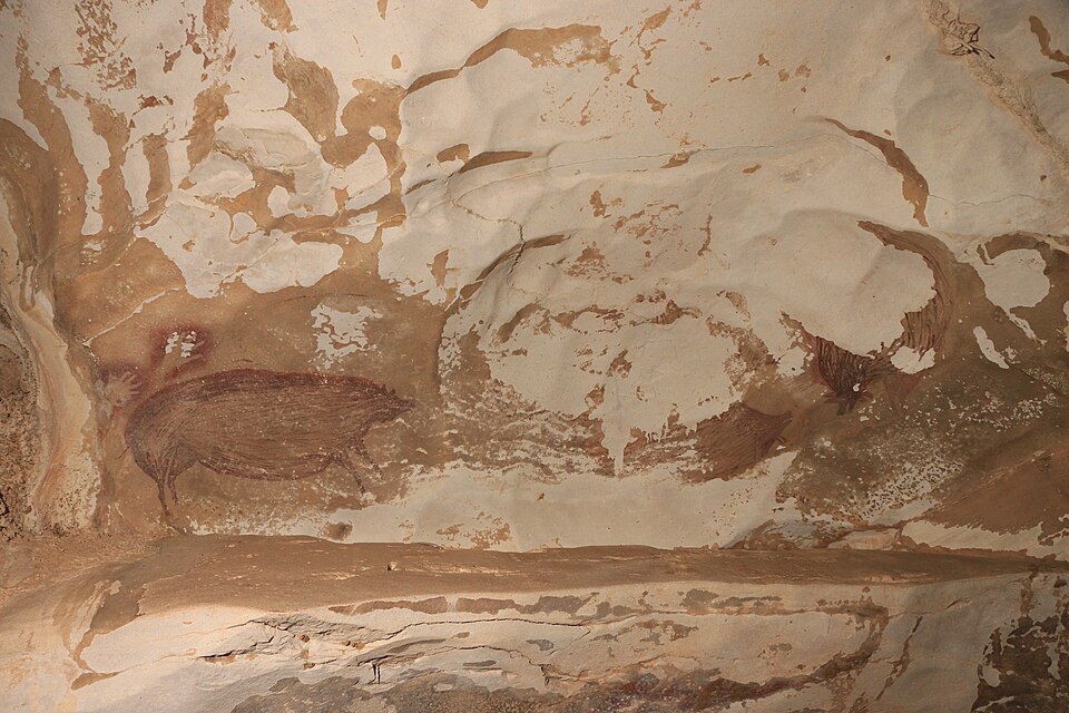 Prehistoric rock art panel at Leang Tedongnge South Sulawesi showcasing the oldest figurative art history and prehistoric art evolution.