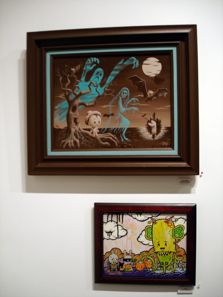 Pop Surrealism framed paintings on display at Corey Helford Gallery Halloween exhibition featuring lowbrow spooky character art.