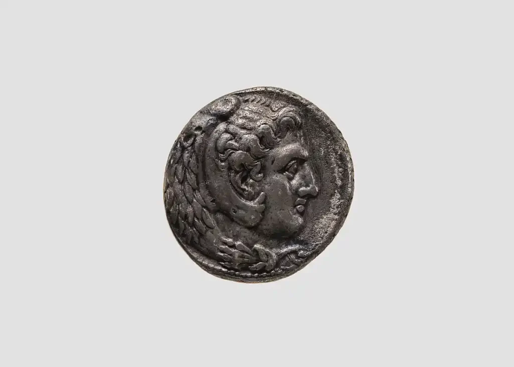 Silver Hellenistic Tetradrachm coin depicting Herakles wearing a lion pelt headpiece, representing Alexander the Great.